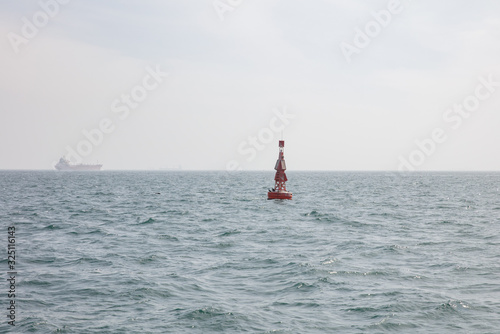 Rote Boje vor Frachtschiff
