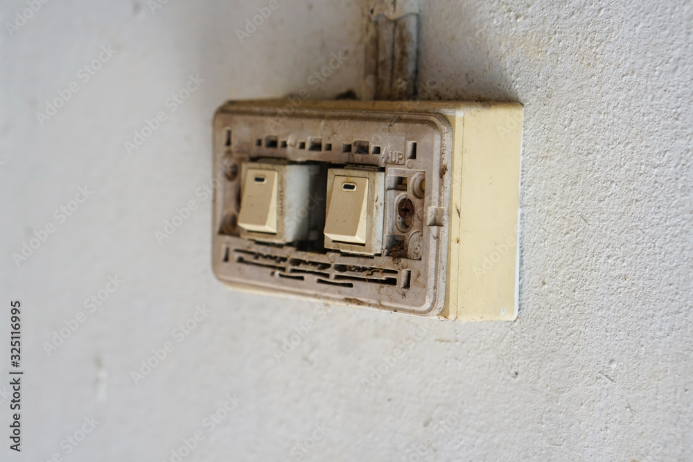 Old power switch for lamp, Old light switch without cover on the white cement wall. Old power switch for lamp, Old light switch without cover on the white cement wall.