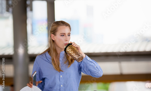 young woman drinking water from cup at outside