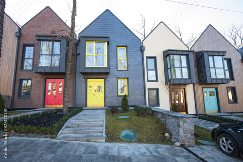 Modern hitech townhouses in a residential building settlement with green outdoor facilities in diffrent styles along the road