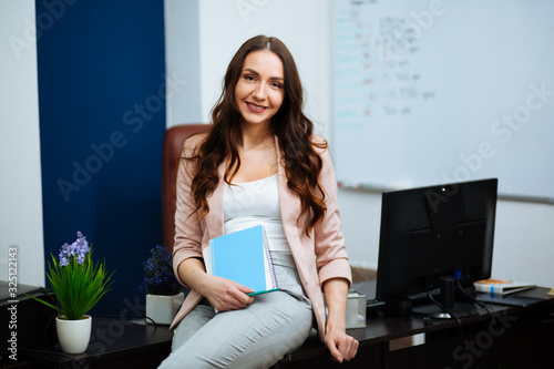 beautiful smart cute charming attractive elegant owner of a big company has an online meeting with international business partners  she sits at a desk in the workplace