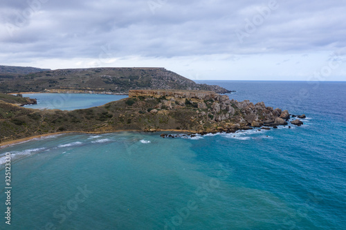 Ghajn Tuffieha, Malta - Aerial panoramic view of the coast of Ghajn Tuffieha with Gnejna Bay, Riviera Bay and Golden Bay at sunrise