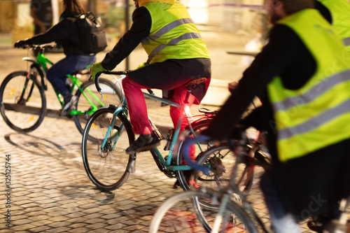 Radfahrer mit Warnewesten im abendlichen Stadtverkehr photo