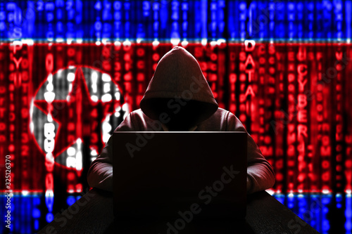 Cyber threat from North Korea. North Korean hacker at the computer, on a background of binary code, the colors of the flag of the DPRK. DDoS attack