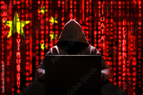 Cyber threat from china. Chinese hacker at the computer, on a background of binary code, the colors of the Chinese flag. DDoS attack