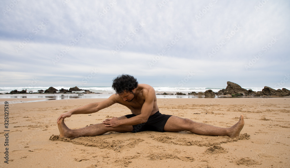 A black man stretches his legs on the beach A black man stretches his legs on the beach