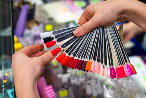 Woman chooses nail polish in a store