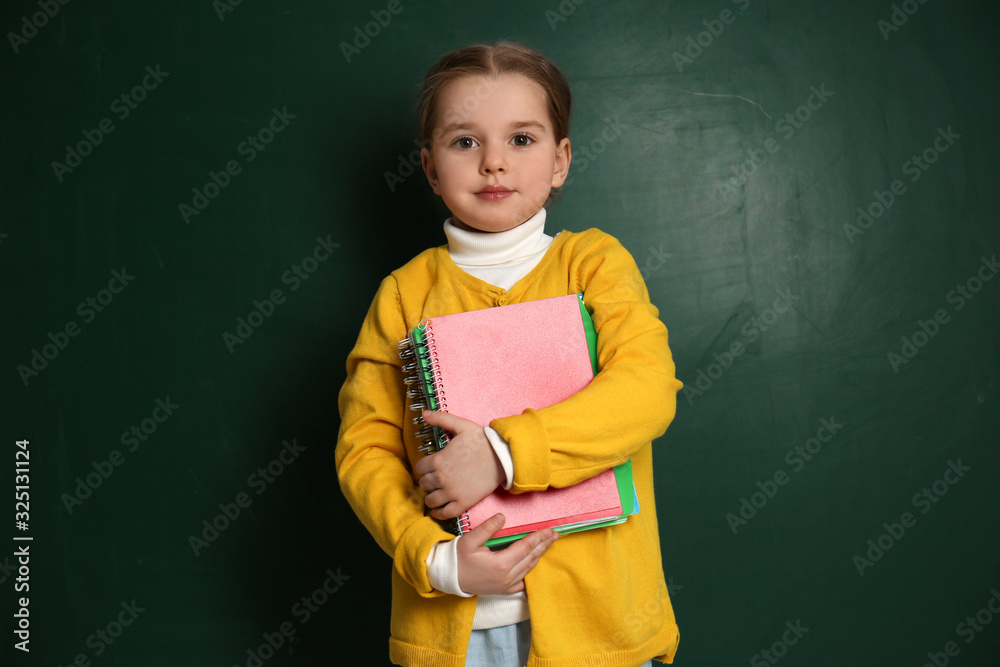 Cute little child near chalkboard. First time at school