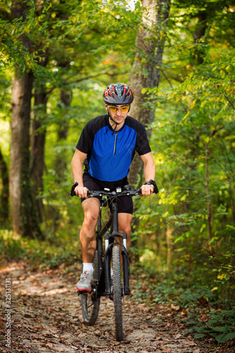 Cyclist riding the bike on the trail in the forest