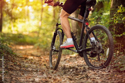 Muscular legs and mountain bike photo
