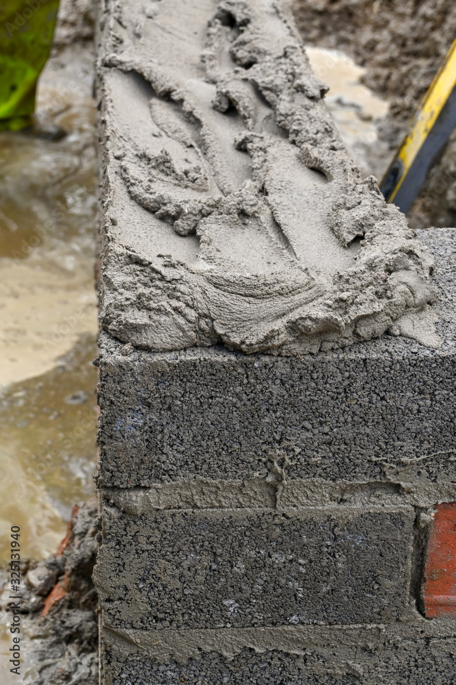 Bed of mortar ready for the next layer of concrete blocks being laid to ...