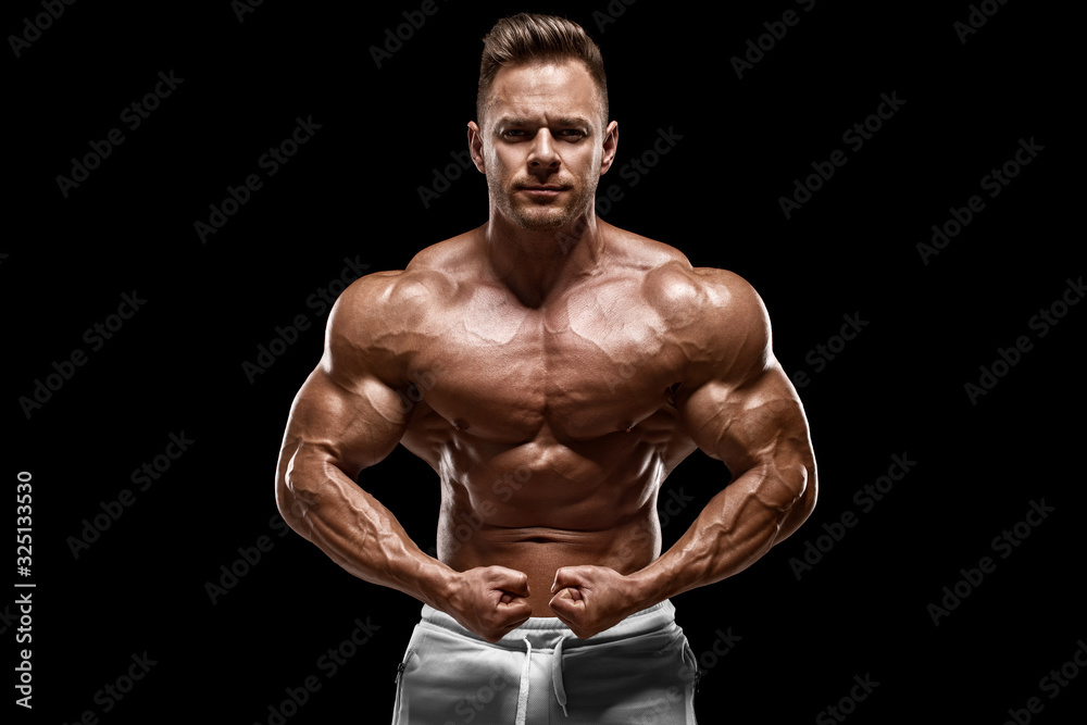 Muscular man showing muscles isolated on the black background. Strong male  naked torso abs Stock Photo