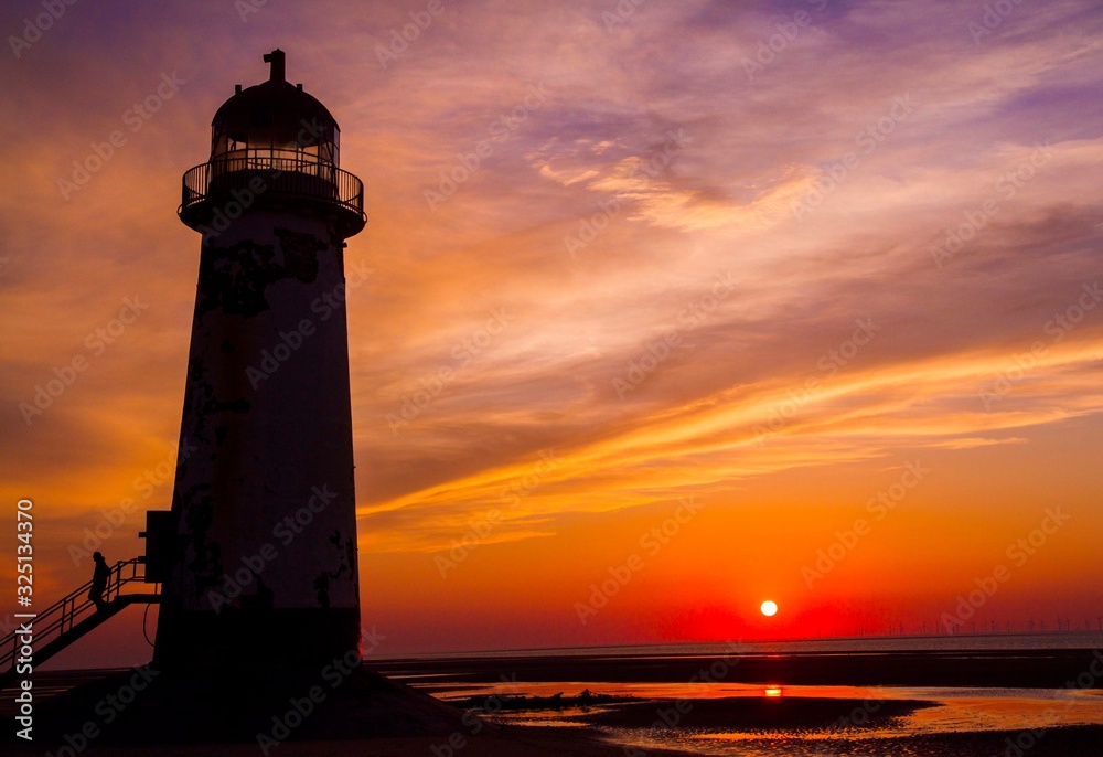 Coastal photograph of a lighthouse at sunset