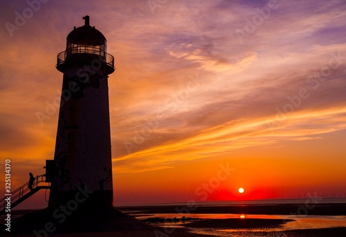 Coastal photograph of a lighthouse at sunset