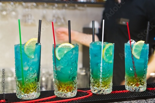 set of alcohol cocktails in glasses, served in bar, waiting for visitors of a club, shallow dof, spirituous tasty beverage image