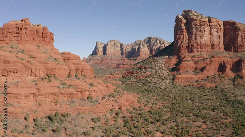 A drone flying past trees towards Courthouse Butte rock formation in Sedona, Arizona. A drone flying past trees towards Courthouse Butte rock formation in Sedona, Arizona.