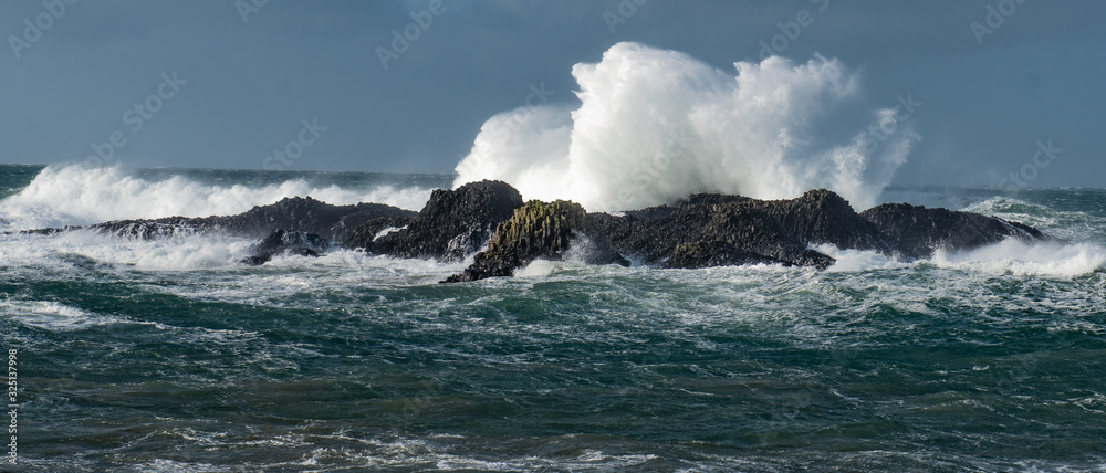 Massive waves crash over the rocks at Ballintoy Harbour, Causeway Coast, Northern Ireland Massive waves crash over the rocks at Ballintoy Harbour, Causeway Coast, Northern Ireland