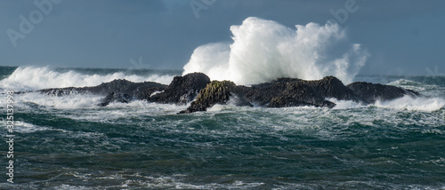 Massive waves crash over the rocks at Ballintoy Harbour, Causeway Coast, Northern Ireland