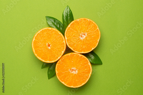 Tangerine on an green background, fruit flatlay, summer minimal compositon