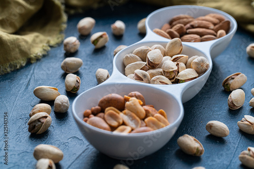 Roasted Nuts And Salted Pistachios In White Ceramic Bowl