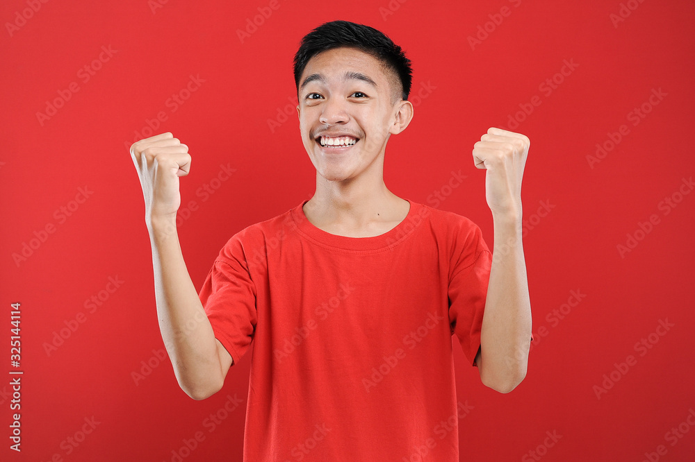 Young Asian teenager doing winning gesture, Happy get special gift Young Asian teenager doing winning gesture, Happy get special gift