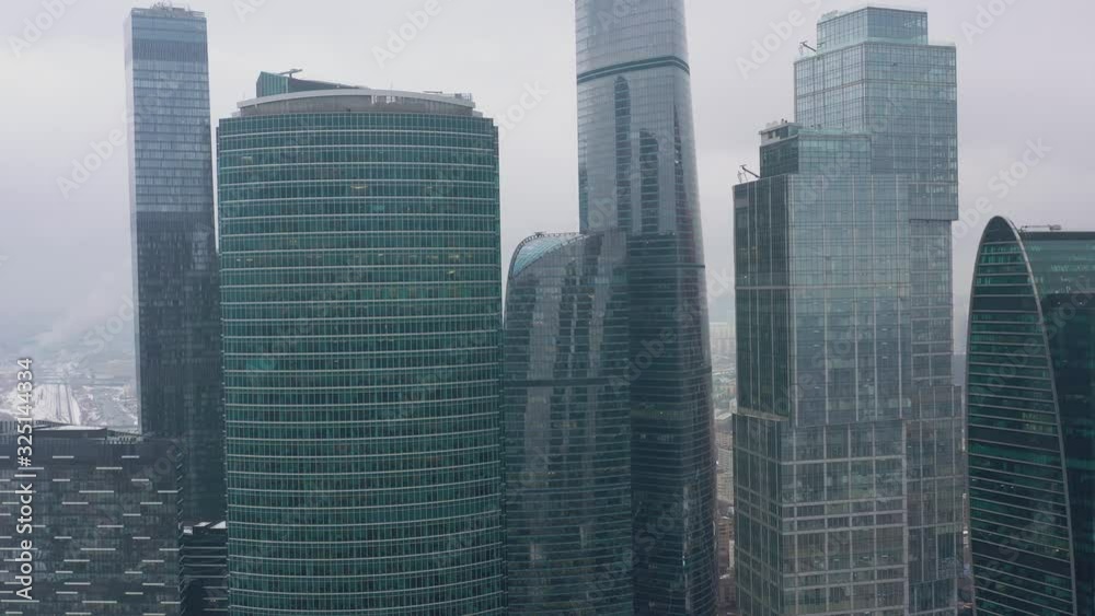 Aerial drone shot flying over center of Moscow city buildings, skyscrapers at cloudy winter day. Drone shot flying over Moscow skyscrapers.