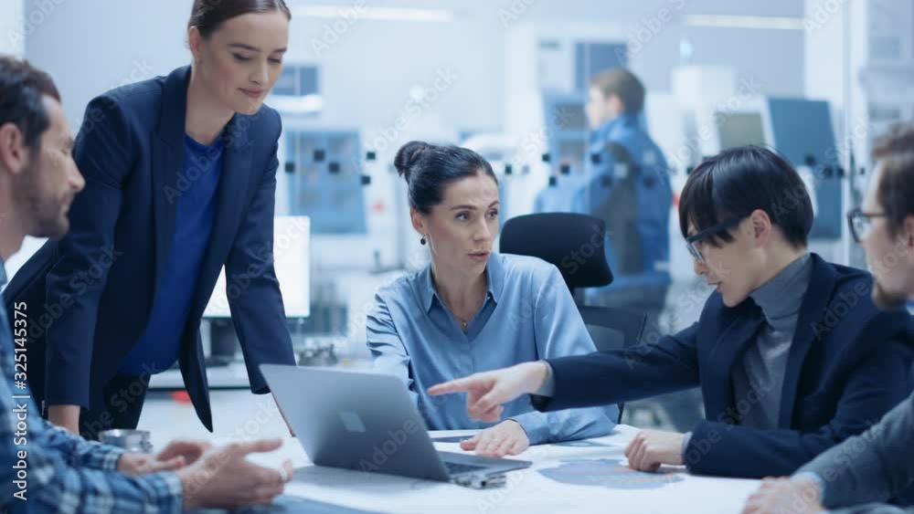 Modern Factory Office Meeting Room: Confident Female Project Manager Talks to Diverse Team of Engineers, Businesspeople and Investors Sitting at the Conference. Manufacturing Facility Optimization Modern Factory Office Meeting Room: Confident Female Project Manager Talks to Diverse Team of Engineers, Businesspeople and Investors Sitting at the Conference. Manufacturing Facility Optimization