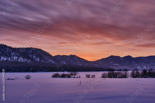 Winter mountain landscape. Orange-purple winter sunset in the mountains. Russia. Republic of Altai. © Alexey