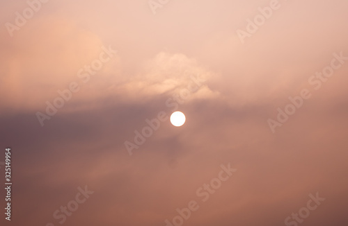 A hazy winter morning sunrise behing the fog and clouds photo