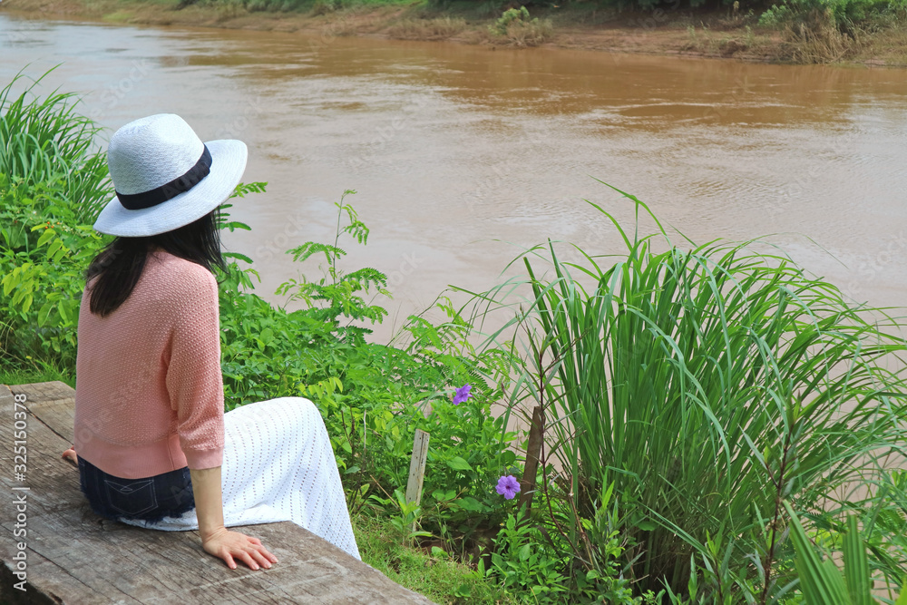 Εκτύπωση καμβά woman sitting on the wooden bench by the river