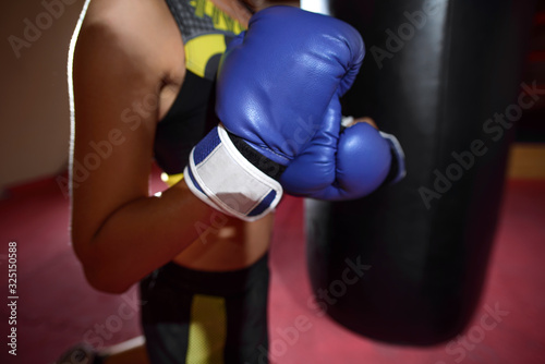 Girl puts on Boxing gloves in the sport gym. close up © sheikoevgeniya