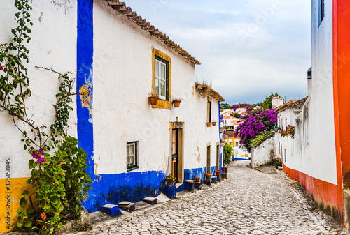 View on Narrow White Blue Street in Mediieval City Obidos Portugal photo