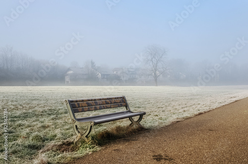 Mist morning path, and a bench in the forest frost