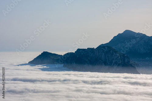 The island of Capri shrouded in an unusual fog. Punta Campanella, Naples, Campania, Italy