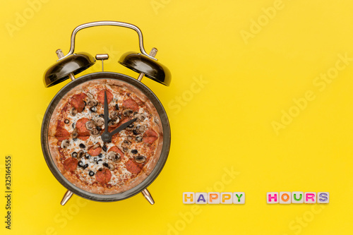 Alarm clock with pizza dial on yellow background with words 