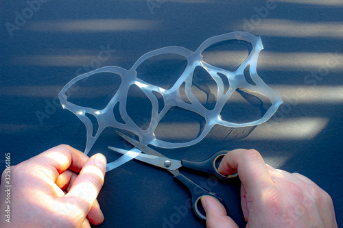 фотография A person cutting a six pack rings or six pack yokes with scissors