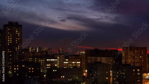 Time lapes cities. Evening shooting of houses, the sun sets, hides behind the clouds. On the street, night falls.