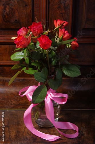 Red roses bouqet on the vintage old wooden piano