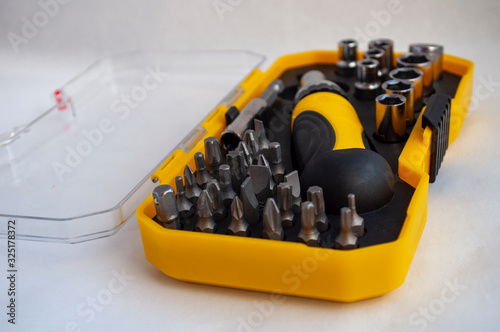 equiped Tool Kit. Instrument. Miter heads and keys. compact set in a yellow plastic box with a transparent cover.tools kit detail close up photo