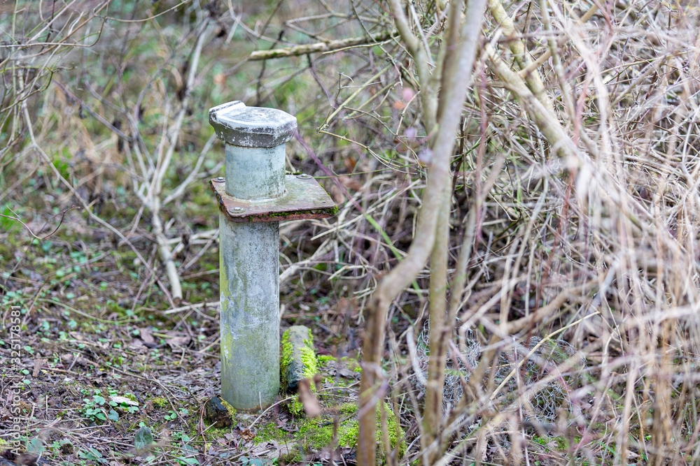 old groundwater observation well in the bushes with moss old groundwater observation well in the bushes with moss