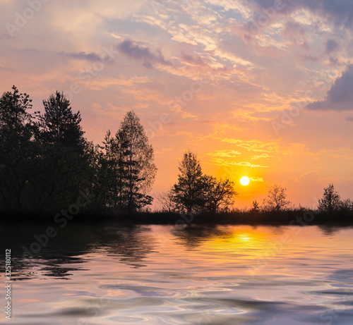 forest silhouette on a lake coast at the sunset, good outdoor background