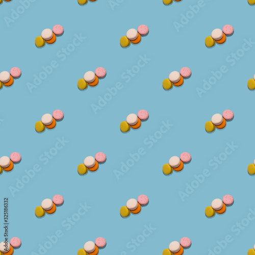 Seamless pattern heap of four multi-colored macaroon on blue background
