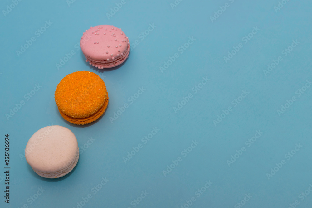 Obraz premium Three multi-colored macaroon on flat background