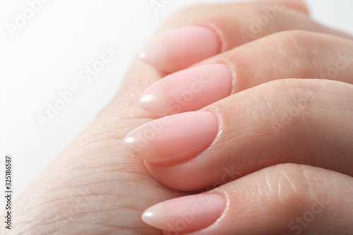 Women s hands with perfect Nude manicure. Nail Polish is a natural pale pink shade.