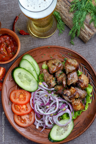 pork skewers with a side dish of vegetables