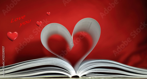 Serce z kart książki na czerwonym tle. 