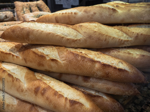 A stack of freshly-baked French bread baguettes on sale at an traditional artisan bakery in a public market in Vancouver, Canada.