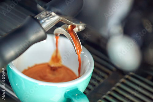 Coffee shop. Espresso machine making shot into cup close-up