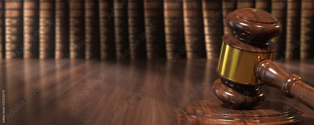 Wooden gavel and books on wooden table