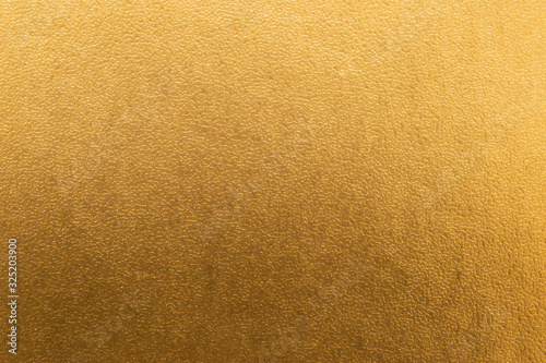 Shiny yellow gold foil texture background with gradient shadow